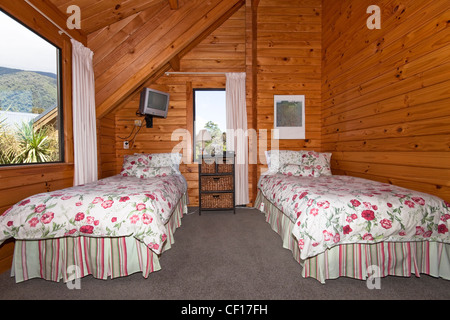 Zwei Betten im Schlafzimmer Holzhütte. Fox Glacier Lodge, Fox Glacier, West Coast, Südinsel, Neuseeland. Stockfoto