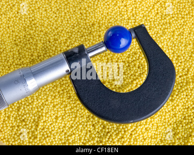 Mikrometer mit Perlen und Kugeln. Bunte Kunststoffperlen und einem Mikrometer messen eine Kunststoff-Kugel Stockfoto