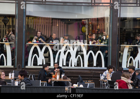 Kunden Essen fast-Food, innen und außen ein McDonald's-Restaurant am Leicester Square in London Stockfoto