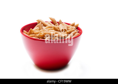 Getrocknete Penne Pasta in einer roten Schüssel auf weißem Hintergrund Stockfoto