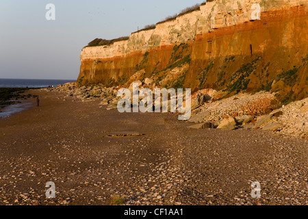 Klippen aus roten und weißen Schichten Sedimentgestein mit horizontalen Schichten in Hunstanton Norfolk Stockfoto