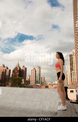 Frau in Sportkleidung auf Dach Stockfoto