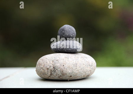 3 Steinen steht auf gegenseitig im Gleichgewicht. Es ist eine visuelle auf Natur/grün Hintergrund Zen. Es ist ein Symbol, ein Wohlbefinden, gesunde Stockfoto