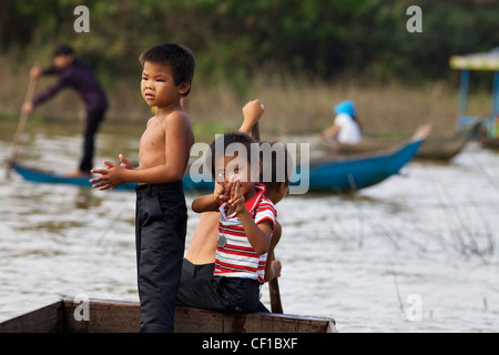 Drei kambodschanische Kinder Rudern ihre Boot auf dem Tonle Sap See in Siem Reap, Kambodscha Stockfoto