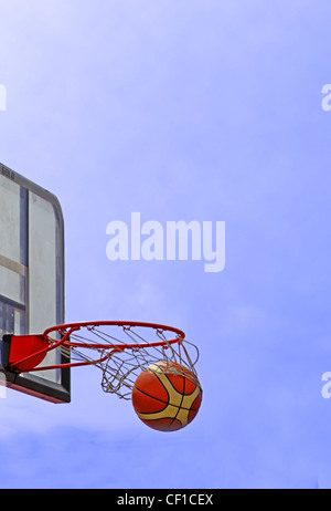 Ein Basketball braust durch die Hoop-Streetball-Match-Detail. Stockfoto