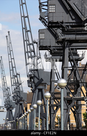 Verfallene Krane stehen als eine Erinnerung an die Vergangenheit am Royal Victoria Dock in den sanierten Docklands von London. Stockfoto