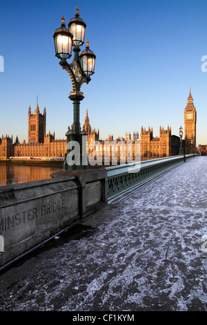 Ein eisiger Fahrbahn über Westminster Bridge Blick auf Big Ben und den Houses of Parliament bei Sonnenaufgang im Winter. Stockfoto