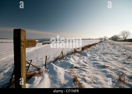 Ein öffentlicher Wanderweg-Wegweiser auf dem Schnee bedeckt Wolds Weise. Stockfoto