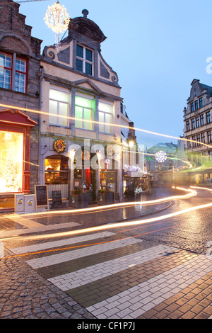 Ein Blick Licht Wanderwege entlang einer traditionellen gepflasterten Stret in Brügge zu Weihnachten Stockfoto