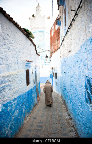 Muslimischen Mann zu Fuß in die blaue ummauerte alte Medina von Chefchaouen, Marokko Stockfoto