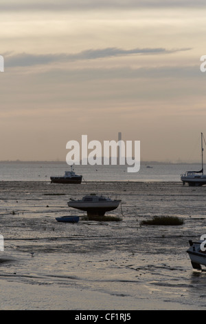 Kleine Boote vor Anker in der Mündung bei Leigh-on-Sea in Essex mit einer Fabrik in weiter Ferne. Stockfoto