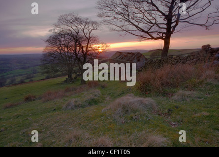 Sonnenuntergang über einem stillgelegten Bauernhof Gebäude am Roach End Farm im Peak District. Stockfoto