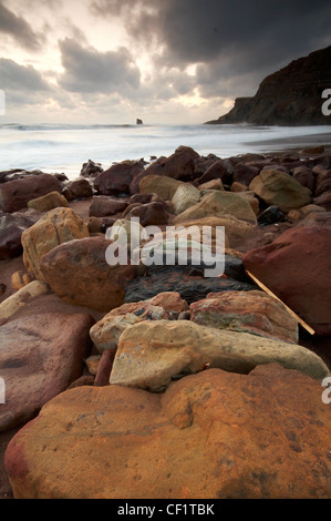 Ein Blick auf die felsige Küste gegen Bay in Richtung der Wellen an den Strand Rollen. Stockfoto