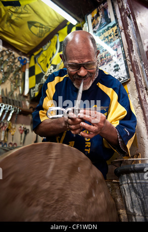 Lokale Mann Schärfen Scheren mit einem Schleifstein in seinem Geschäft, Fes, Marokko Stockfoto