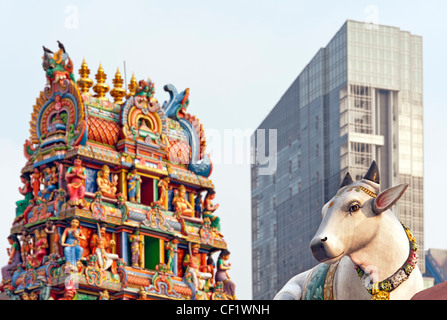 Heilige Kuh vor hindu-Tempel und moderne Wolkenkratzer Stockfoto