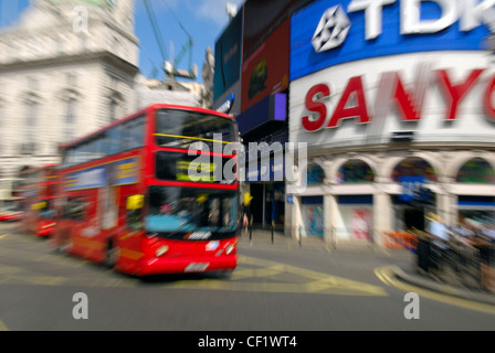 Londoner Busse vorbei an der großen Ikone Werbeschilder am Piccadilly Circus. Stockfoto