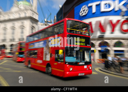 Londoner Busse vorbei an der großen Ikone Werbeschilder am Piccadilly Circus. Stockfoto