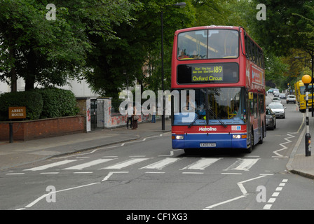 Ein roter Londoner Doppeldeckerbus hielt am berühmten Fußgängerüberweg auf Abbey Road welche Funktionen auf dem Cover von The Beatle Stockfoto