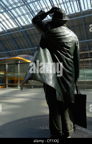 Eine Statue des Dichters John Betjeman von Martin Jennings in St. Pancras International Station, mit dem Eurostar-Zug im Hintergrund. Stockfoto