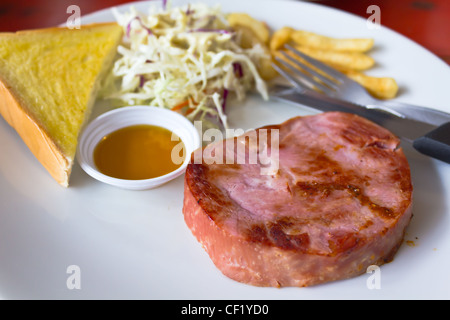 Schinken-Steak mit Brot auf einem weißen Teller Stockfoto