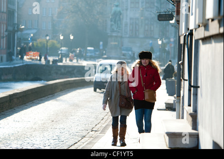 Zwei Damen zu Fuß auf dem Bürgersteig an einem Morgen sonnig aber bitterkalten Wintern. Stockfoto