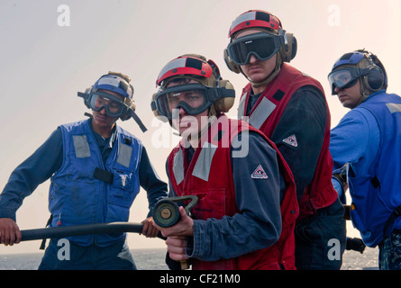 ARABIAN SEA (Feb 21, 2012) Schaden Kontrollmann Feuerwehrmann Keith Modisette und Schaden Kontrollmann 3. Klasse Nicholas Fisher man ein Feuerwehrschlauch während einer Massenopferübung auf dem Flugdeck des geführten Raketenkreuzers USS Cape St. George (CG 71). Cape St. George wird als Teil der Abraham Lincoln Carrier Strike Group in das US-amerikanische 5. Flottengebiet eingesetzt, das maritime Sicherheitsoperationen, Sicherheitskooperationen und Unterstützungsmissionen im Rahmen der Operation Enduring Freedom durchführt. Stockfoto