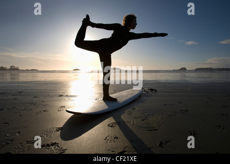 Silhouette der Surferin Bogen ziehen Yoga-Pose zu tun; Chesterman Beach Tofino Vancouver Island in British Columbia Kanada Stockfoto