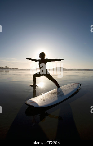 Silhouette der Surferin Krieger Yoga-Pose zu tun; Chesterman Beach Tofino Vancouver Island in British Columbia Kanada Stockfoto