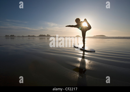 Silhouette der Surferin Bogen ziehen Yoga-Pose zu tun; Chesterman Beach Tofino Vancouver Island in British Columbia Kanada Stockfoto