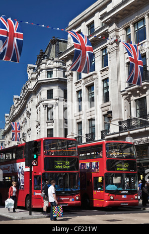 Roten Doppeldecker-Busse warten an der Ampel unter roten, weißen und blauen Bunting aufgereiht über Regent Street, feiern die Stockfoto