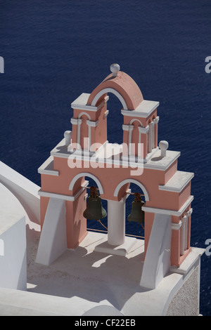 Ein Blick auf eine rosa lackierte Glockenturm thront auf einem Kirchendach mit dem Meer unten Stockfoto