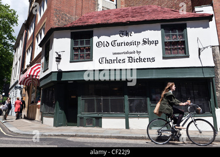 Eine Frau mit dem Fahrrad vorbei an der Old Curiosity Shop, Ladengeschäft sechzehnten Jahrhundert verewigt, von Charles Dickens und möglicherweise die Stockfoto