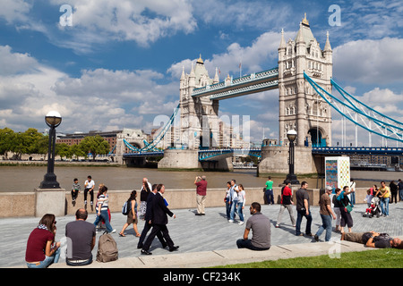 Menschen zu Fuß entlang der Themse Weg am Südufer von Tower Bridge. Stockfoto