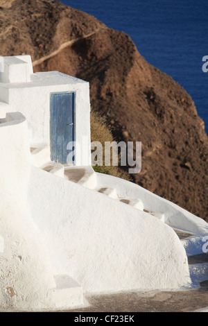 Ein Blick auf einem traditionellen bemalte Höhle Haus im Dorf Oia thront auf einem Felsen über der Caldera von Santorin Stockfoto