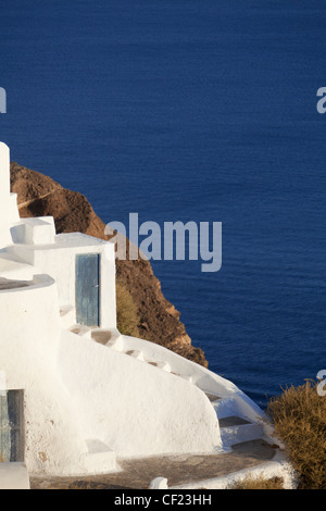 Ein Blick auf einem traditionellen bemalte Höhle Haus im Dorf Oia thront auf einem Felsen über der Caldera von Santorin Stockfoto