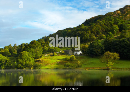 Reflexionen der typischen Landschaft der Seenplatte in den stillen Wassern des Loughrigg Tarn. Stockfoto