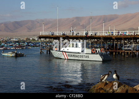 Peruanischen Küstenwache Schiff vertäut neben historischen Pier, Fischereihafen im Hintergrund, Ilo, Peru Stockfoto