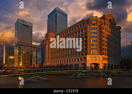 Fußgängerbrücke über West India Quay mit One Canada Square und 8 Canada Square, der zweiten und neunten höchsten Gebäude im Vereinigten Königreich in Stockfoto