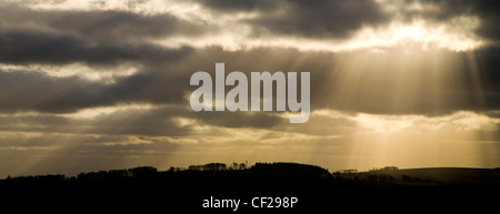 Lichtstrahlen durchbrechen Gewitterwolken in der Nähe von Harelaw Moor. Stockfoto