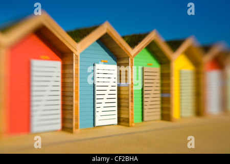 Neue farbenfrohe Strandhütten auf der Promenade am Strand von Blyth. Stockfoto