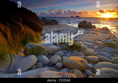 Sonnenuntergang in Porth Nanven, lokal bekannt als Dinosaurier-Ei-Strand aufgrund der großen Anzahl der eiförmigen Felsen dort gefunden. Stockfoto