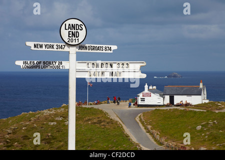 End-Meilenstein mit dem ersten und letzten Haus im Hintergrund landet. Stockfoto