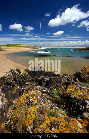 Yachten ankern in einer Bucht vor Llanddwyn Island, ein Gezeiten-Insel vom Festland bei Flut abgeschnitten. Stockfoto