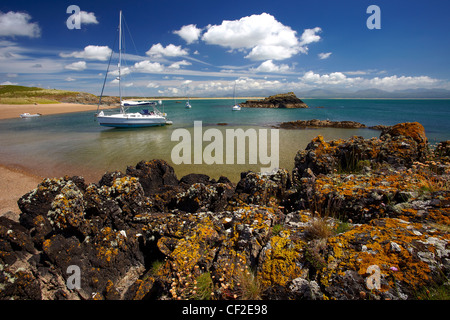 Yachten ankern in einer Bucht vor Llanddwyn Island, ein Gezeiten-Insel vom Festland bei Flut abgeschnitten. Stockfoto