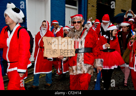 Ein Marsch entlang der South Bank in London von Menschen als Weihnachtsmann verkleidet. Stockfoto