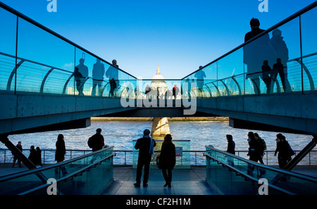 Menschen zu Fuß auf die Millennium Bridge in Bankside mit Blick auf St. Pauls Cathedral am Nordufer der Themse. Stockfoto