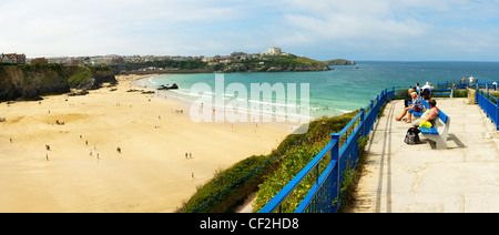 Panoramablick auf Urlauber sitzen auf Bänken mit Blick auf Great Western Beach in Newquay. Stockfoto