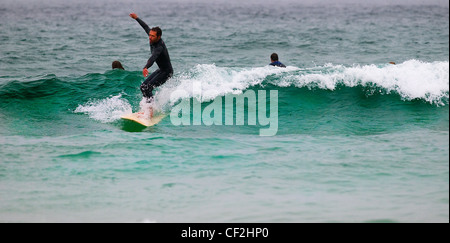 Ein Surfer auf den Wellen bei Sennen. Stockfoto