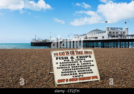 Ein Zeichen Werbung Fastfood auf dem Kiesstrand in der Nähe der Pier in Brighton. Stockfoto