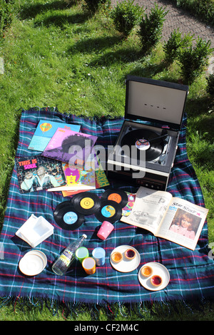 60er Jahre inspiriert Picknick mit Singles & Schallplatten, Plattenspieler, Marmelade Kuchen, Limonade und ein Magazin mit Lulu - Portrait Stockfoto